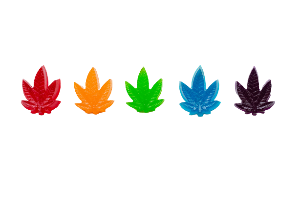 Candy gummies shaped as cannabis leaves over white background
